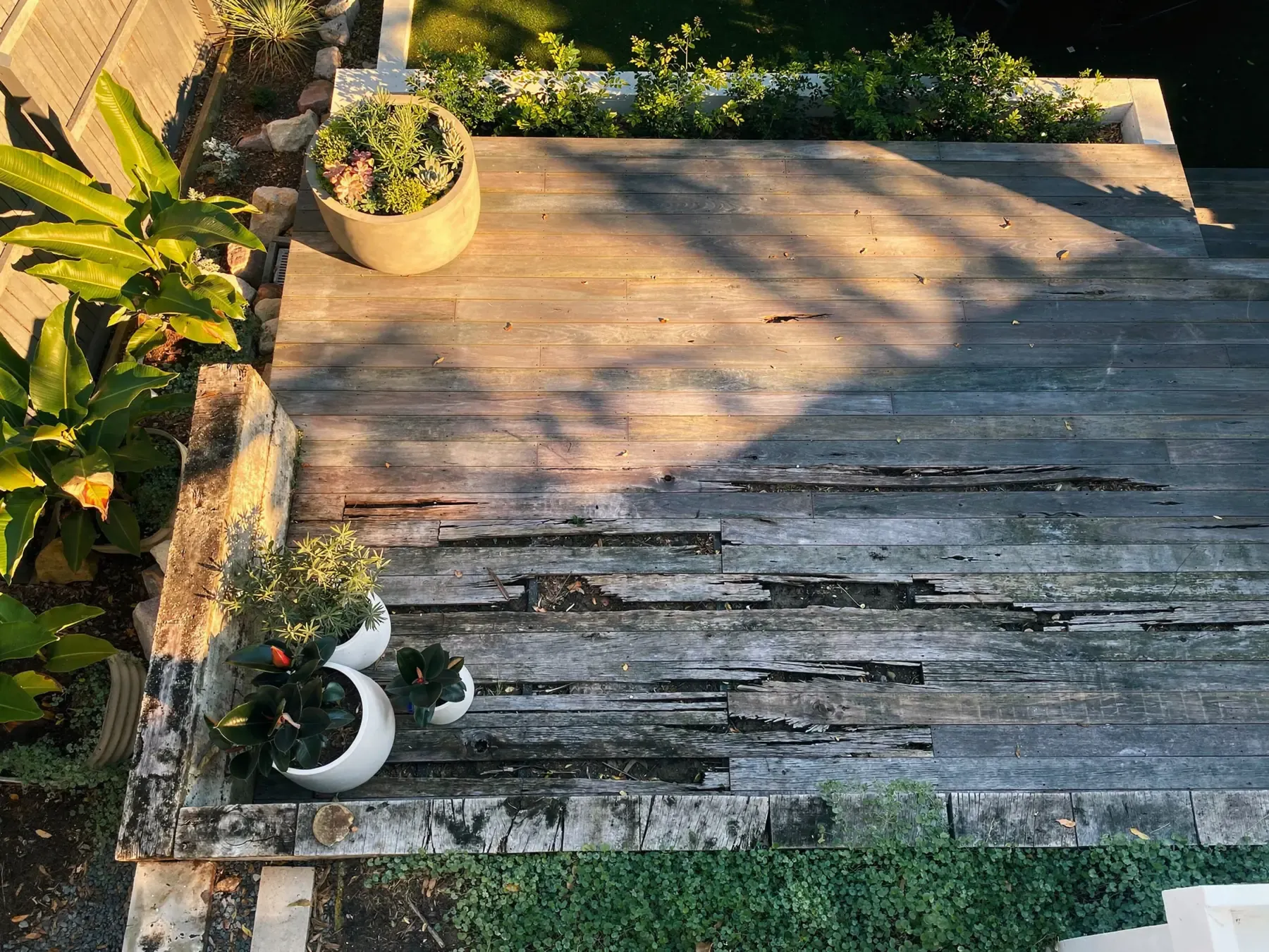Damaged exterior deck showing rot and failed boards from long-term weather exposure